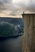 3917497-silhouette-of-preson-standing-at-the-edge-of-immense-cliff-high-above-the-water-lysefjord-norway-sca